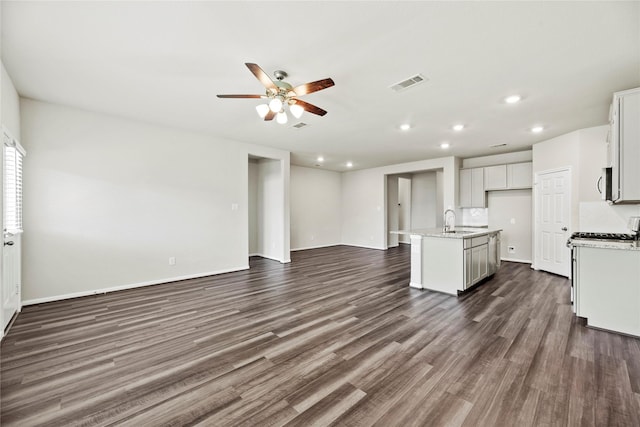 kitchen with sink, white cabinetry, dark hardwood / wood-style floors, ceiling fan, and a kitchen island with sink