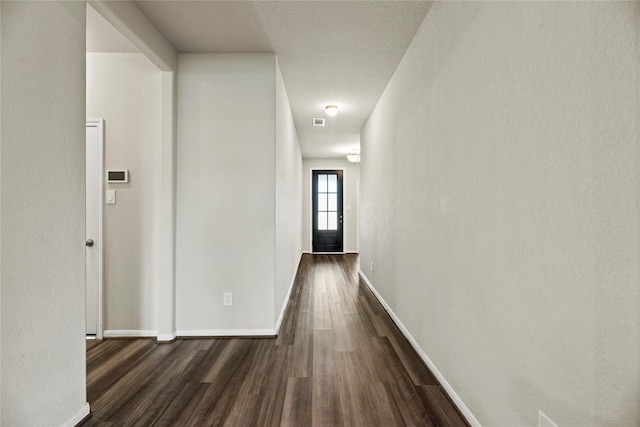 corridor with dark hardwood / wood-style flooring