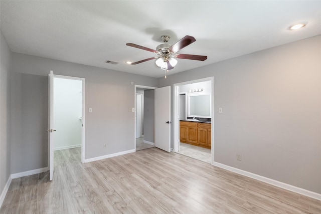 unfurnished bedroom with visible vents, baseboards, ensuite bath, and light wood-style flooring