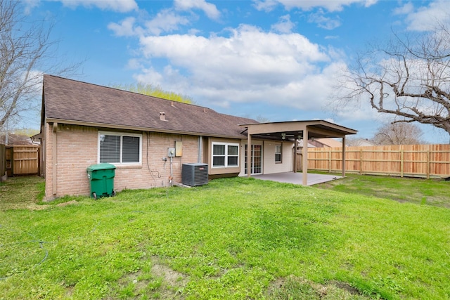 back of house with a patio area, a yard, a fenced backyard, and brick siding