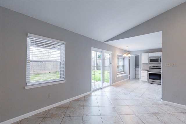 unfurnished living room featuring vaulted ceiling, plenty of natural light, light tile patterned floors, and a chandelier