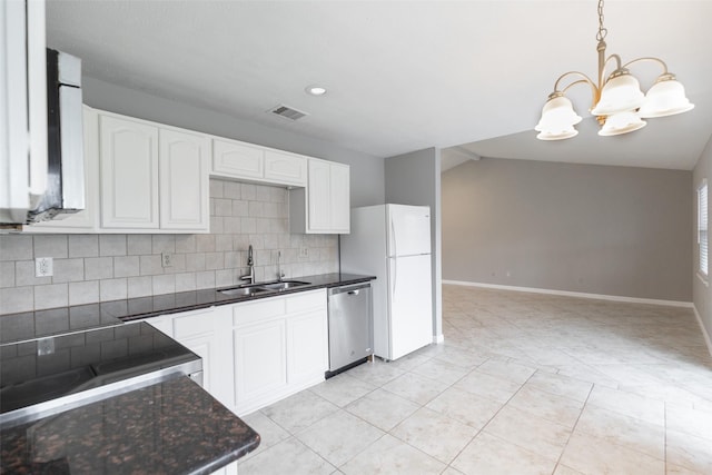 kitchen featuring a sink, tasteful backsplash, freestanding refrigerator, dishwasher, and vaulted ceiling