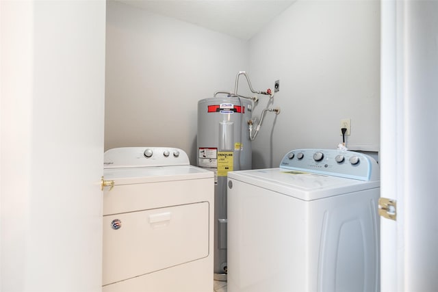 clothes washing area featuring laundry area, water heater, and washing machine and clothes dryer