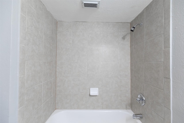 bathroom featuring visible vents, a textured ceiling, and shower / bathtub combination