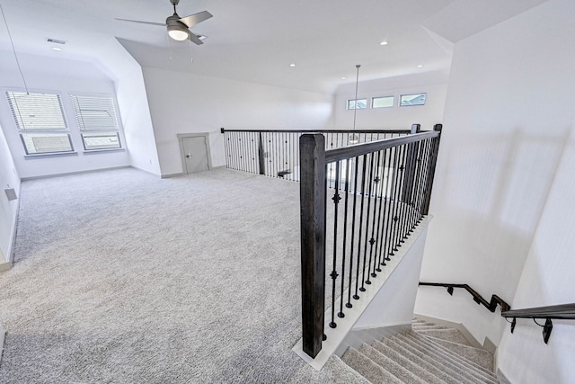 stairs with carpet floors and ceiling fan