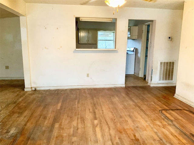 empty room with washer / dryer and hardwood / wood-style floors