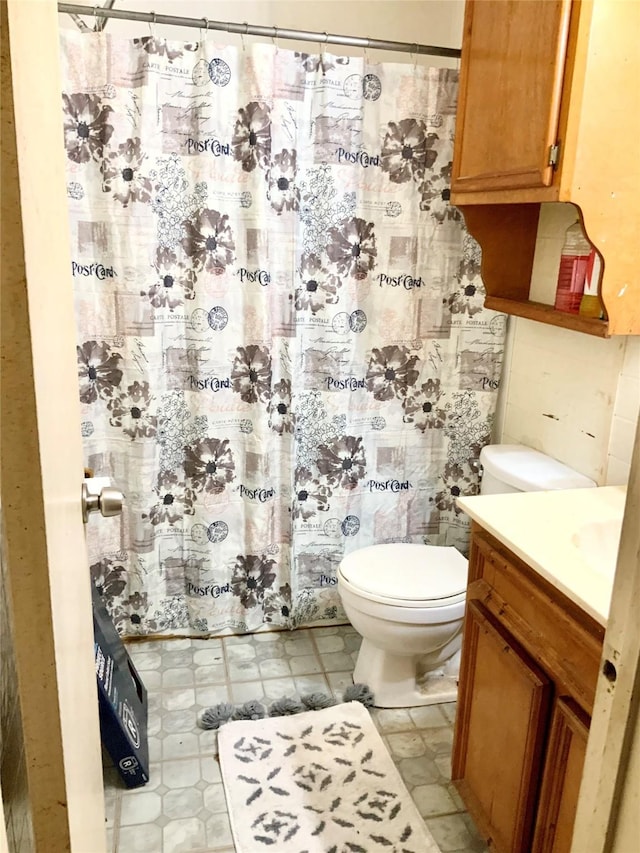 bathroom featuring vanity, curtained shower, and toilet