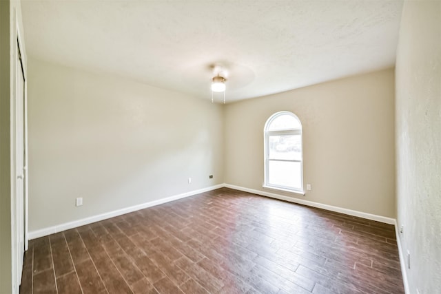 unfurnished room with dark wood-type flooring and ceiling fan