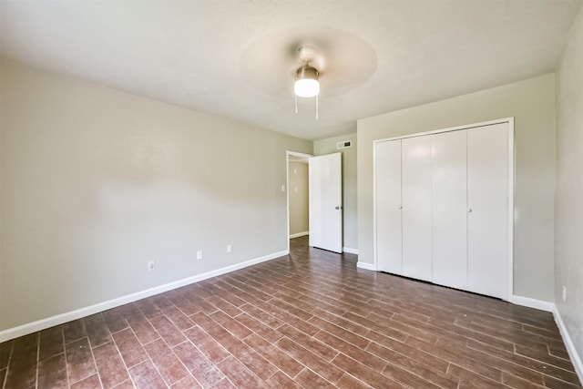 unfurnished bedroom featuring ceiling fan, dark hardwood / wood-style floors, and a closet