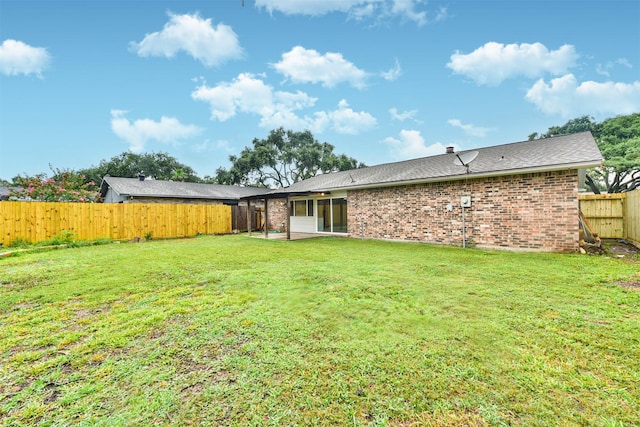 back of house featuring a yard and a patio