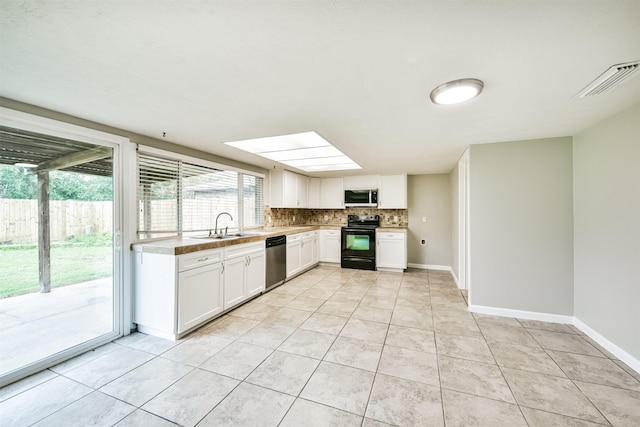 kitchen with white cabinetry, sink, light tile patterned flooring, and appliances with stainless steel finishes