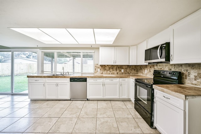 kitchen featuring black / electric stove, stainless steel dishwasher, white cabinetry, and sink