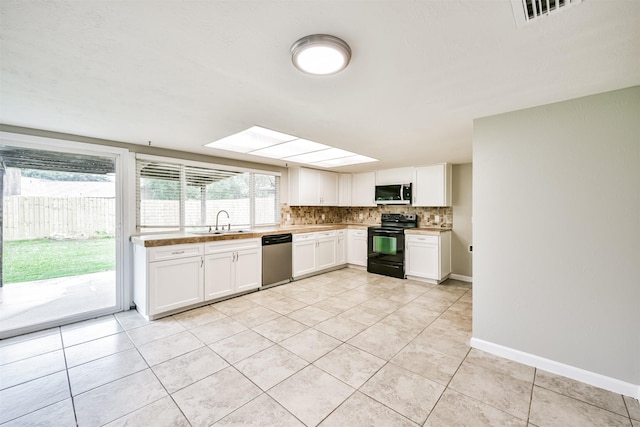 kitchen with sink, tasteful backsplash, light tile patterned floors, stainless steel appliances, and white cabinets