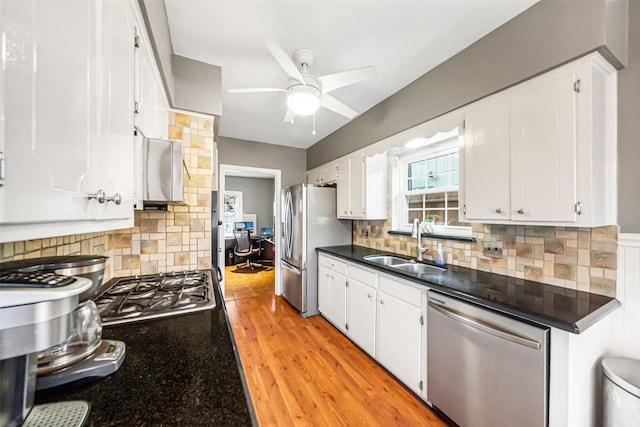 kitchen with sink, tasteful backsplash, light hardwood / wood-style flooring, stainless steel appliances, and white cabinets