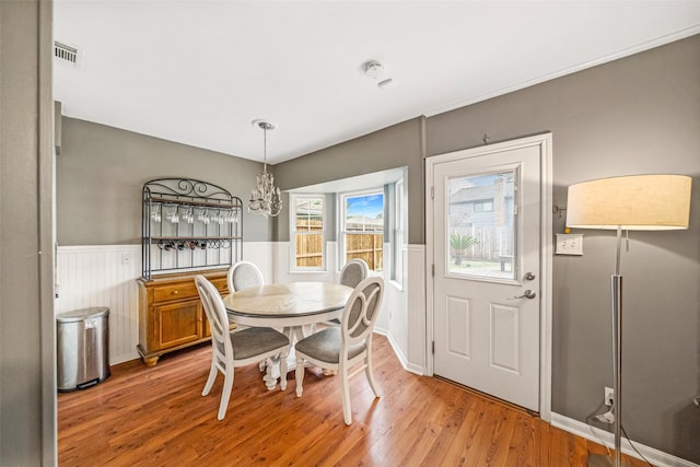 dining area featuring light hardwood / wood-style floors and a notable chandelier