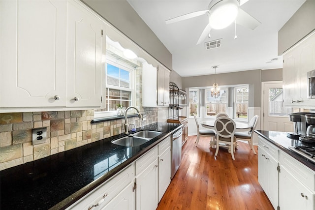 kitchen featuring dishwasher, sink, and white cabinets