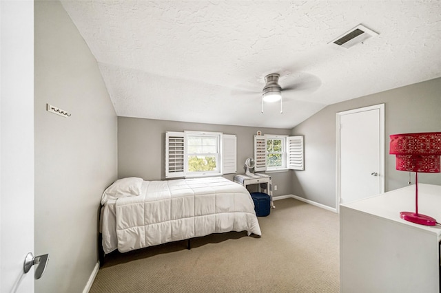 carpeted bedroom with ceiling fan, lofted ceiling, and a textured ceiling