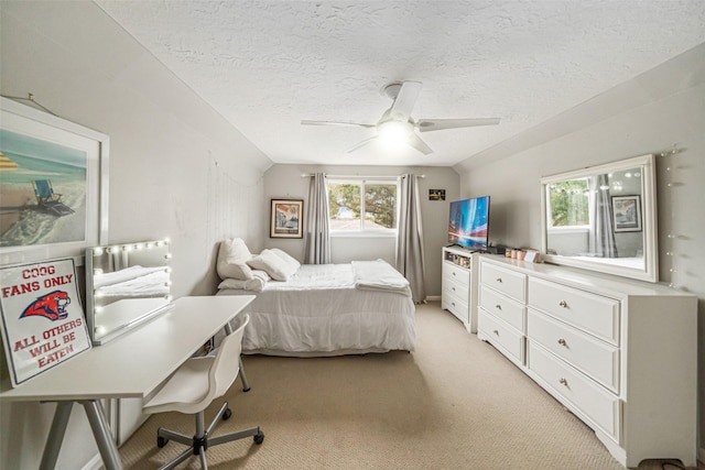 carpeted bedroom with a textured ceiling, vaulted ceiling, and ceiling fan