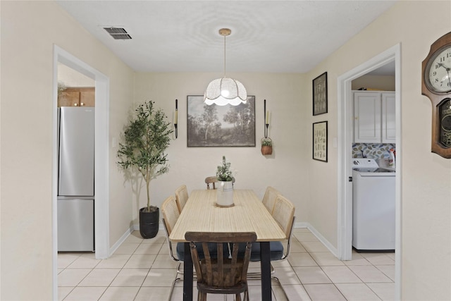 dining space with washer / clothes dryer and light tile patterned floors