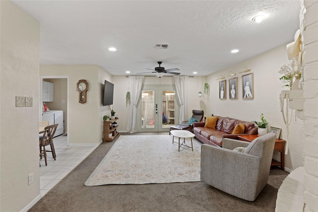 living room featuring light tile patterned floors, washer and clothes dryer, ceiling fan, a textured ceiling, and french doors