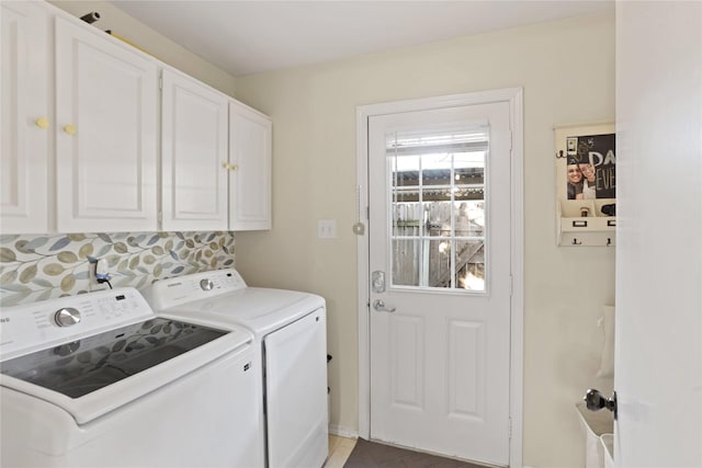 clothes washing area with washer and clothes dryer and cabinets