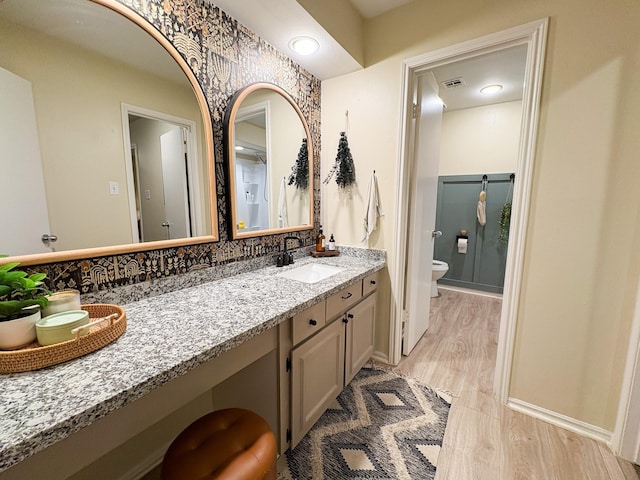 bathroom with hardwood / wood-style flooring, vanity, and toilet