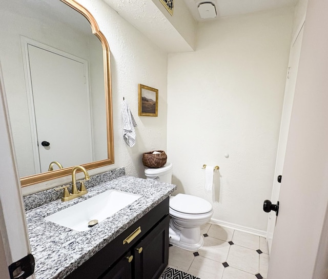 bathroom with vanity, tile patterned floors, and toilet