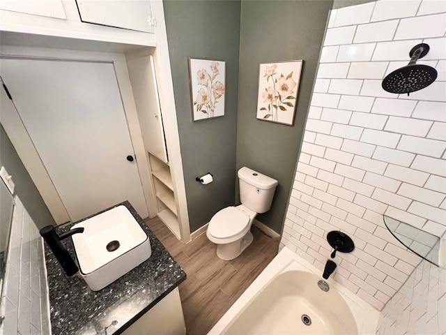 full bathroom with tiled shower / bath, vanity, toilet, and wood-type flooring