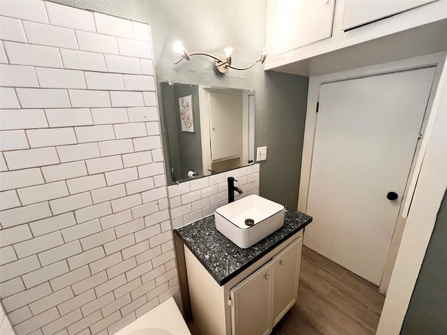 bathroom featuring vanity, decorative backsplash, and hardwood / wood-style flooring