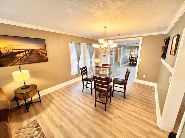 dining area featuring an inviting chandelier, hardwood / wood-style floors, crown molding, and a textured ceiling