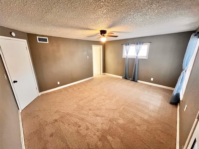 unfurnished bedroom featuring carpet flooring, a textured ceiling, and ceiling fan