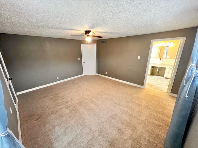 carpeted empty room featuring ceiling fan and a textured ceiling