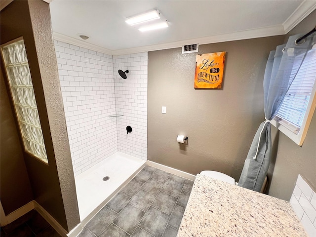 bathroom with crown molding and tiled shower