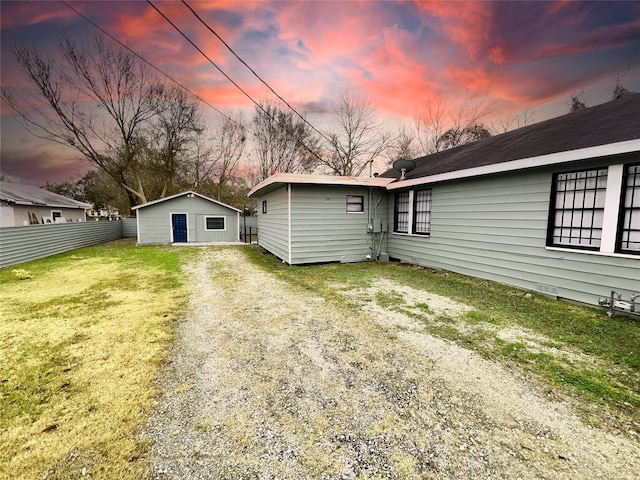 back house at dusk featuring a yard