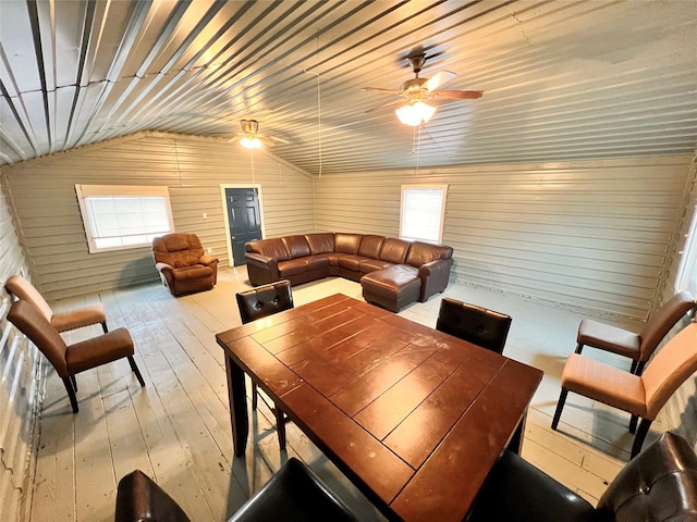 dining room featuring light hardwood / wood-style flooring, wooden ceiling, ceiling fan, and wood walls