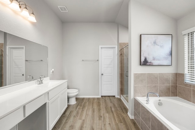 full bathroom with toilet, separate shower and tub, vaulted ceiling, vanity, and hardwood / wood-style flooring