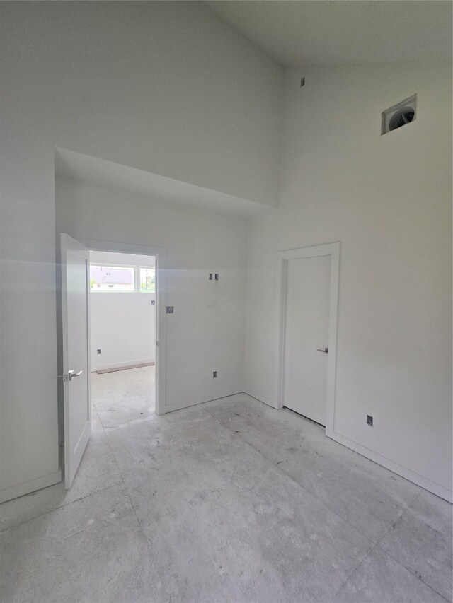 9630 Burden St, Houston, TX 77093 - empty room featuring a towering ceiling and unfinished concrete floors