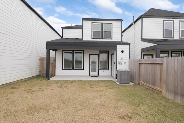 rear view of house with central AC unit, a patio area, and a lawn