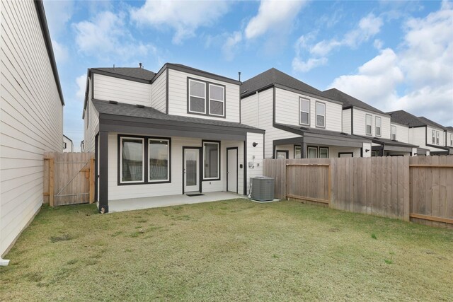 rear view of house with cooling unit, a yard, and a patio