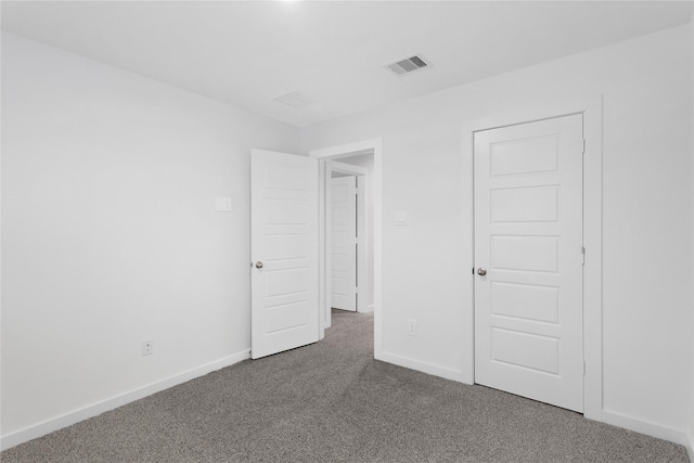 unfurnished room featuring dark carpet