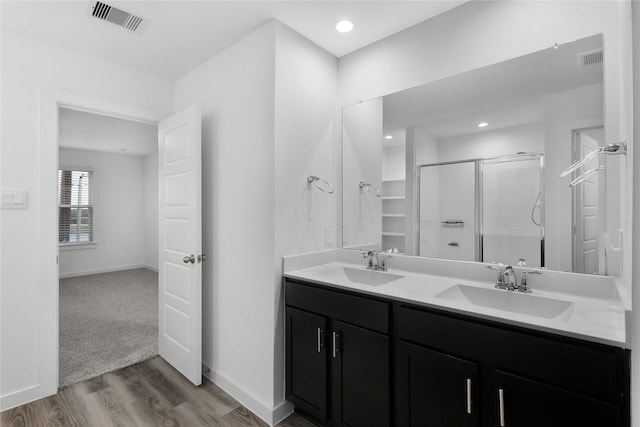 bathroom featuring a shower with door, wood-type flooring, and vanity