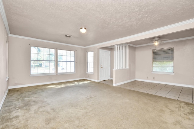 spare room featuring ceiling fan, ornamental molding, tile patterned floors, and a textured ceiling