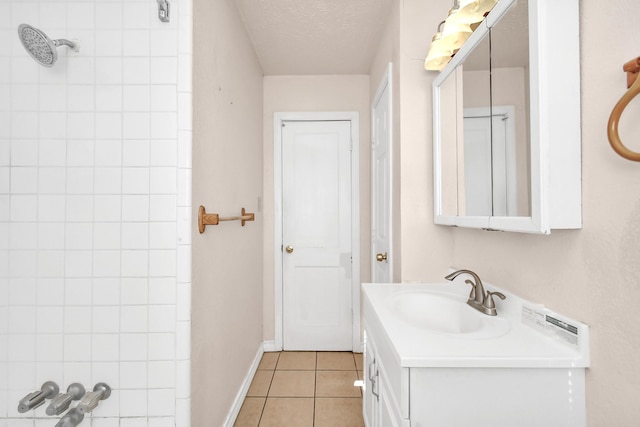 bathroom featuring tile patterned flooring, vanity, a shower, and a textured ceiling