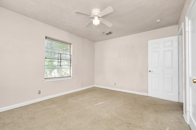 carpeted spare room with a textured ceiling and ceiling fan