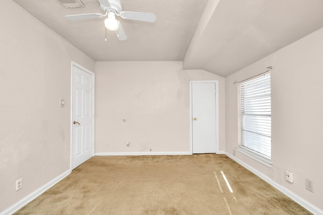 carpeted empty room with ceiling fan and vaulted ceiling