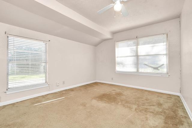 empty room featuring carpet floors, vaulted ceiling, and ceiling fan