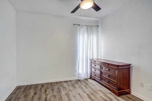 interior space with a textured ceiling, ceiling fan, and light hardwood / wood-style flooring