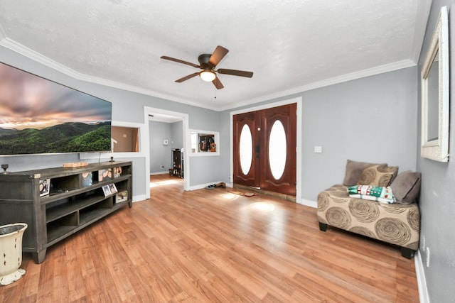 foyer with ceiling fan, ornamental molding, and light hardwood / wood-style flooring