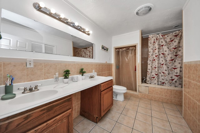 bathroom with tile walls, vanity, a textured ceiling, tile patterned floors, and toilet