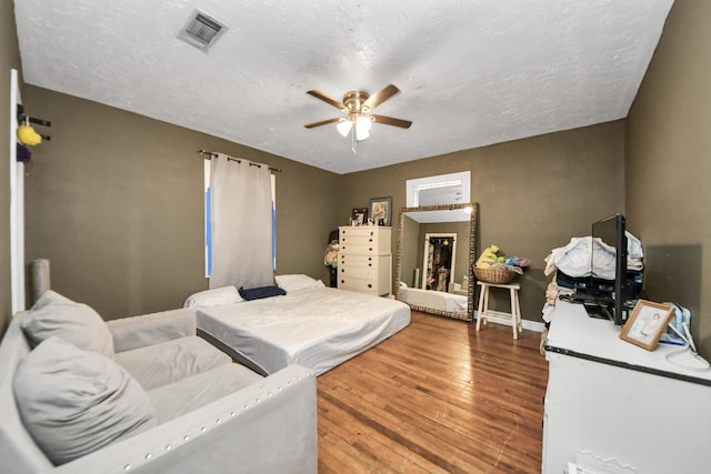 bedroom featuring hardwood / wood-style flooring, a textured ceiling, and ceiling fan